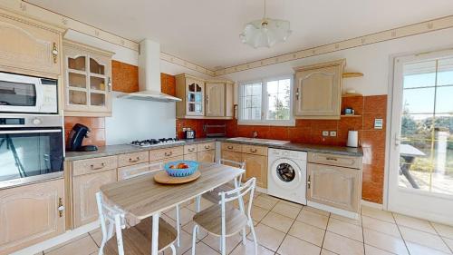 une cuisine avec une table et une cuisinière four supérieur dans l'établissement Le Secret des Marees, à Givrand