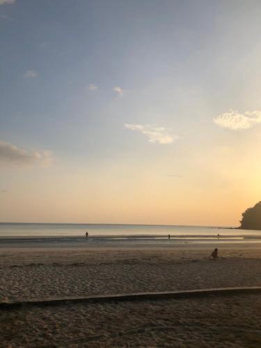 a beach with people on the sand and the ocean at Baiyok House in Ban Ai Dao