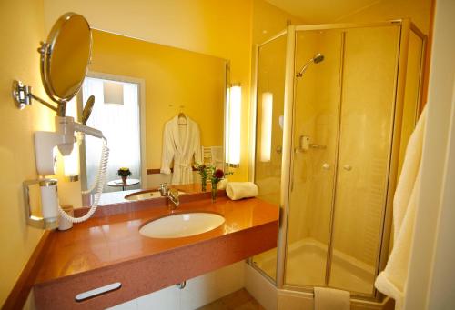 y baño con lavabo y ducha. en Hotel Johannisbad en Bad Aibling