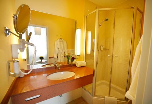 a bathroom with a sink and a shower at Hotel Johannisbad in Bad Aibling