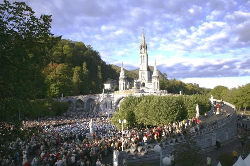 a large crowd of people standing in front of a building at Hôtel Alliance in Lourdes