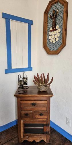 a room with a wooden dresser with a stained glass window at Casa temporada Vô Panta in Bichinho