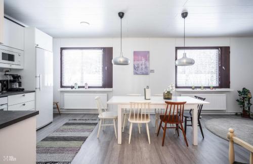 a kitchen and dining room with a table and chairs at Perinteikäs 3 makuuhuoneen koti in Kainuu