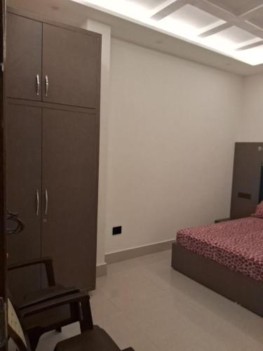 a bedroom with a bed and a cabinet and a chair at Bholenath Homestay Dalhousie in Dalhousie