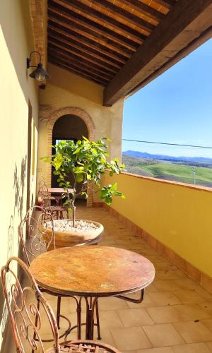 a patio with two tables and chairs and a window at Podere Campiano in Volterra