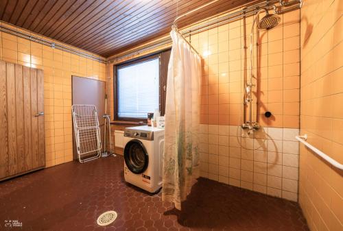 a bathroom with a washing machine and a window at Perinteikäs 3 makuuhuoneen koti in Kainuu