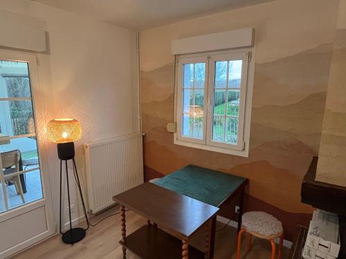 une chambre avec une table et deux fenêtres dans l'établissement La Dunette, à Cucq