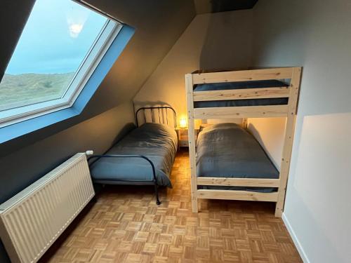 une chambre avec deux lits superposés et une fenêtre dans l'établissement La Dunette, à Cucq