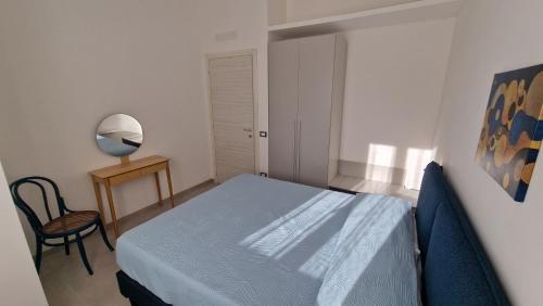 a bedroom with a bed and a table and a chair at Villa Taliala in Alcamo Marina