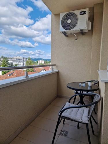 a balcony with a table and a fan at Stan na dan 34 in Banja Luka