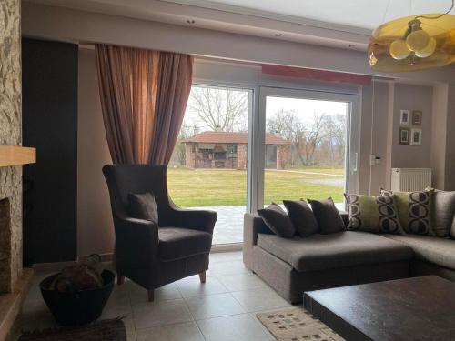 a living room with a couch and a chair and a window at Luxury Heaven farm one in Kastoria