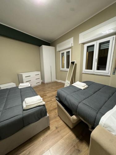 a bedroom with two beds and two windows at Il Rifugio in Piazza in Castel di Sangro