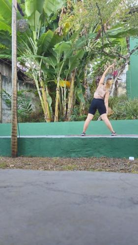 a woman swinging a tennis racket on a tennis court at LahSelva Pousada e Hostel in Itacaré