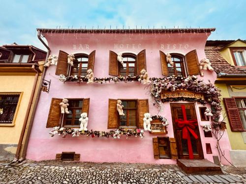 a pink building with teddy bears in the windows at Boutique Hotel von Graf in Sighişoara