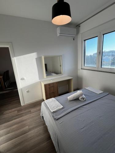 een slaapkamer met een groot bed en een spiegel bij Amore in Ulcinj