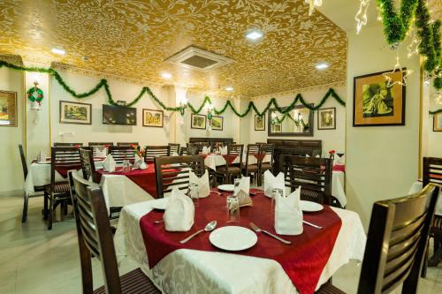 a restaurant with tables with red and white tablecloths at Umaid Residency - A Regal Heritage Home in Jaipur