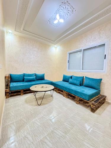 フェズにあるMenzeh saiss appartementの青いソファとテーブルのあるリビングルーム