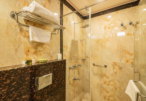 a bathroom with a shower with a glass door at Umaid Residency - A Regal Heritage Home in Jaipur