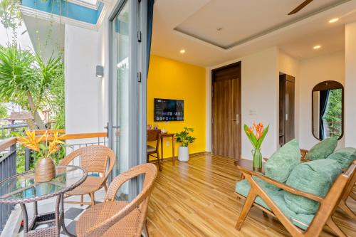 a living room with a glass table and chairs at The Nam An Villa Hoi An in Hoi An