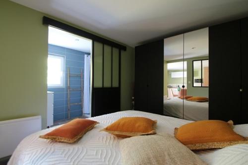 une chambre avec un lit avec deux oreillers et un miroir dans l'établissement Logement indépendant proche Saintes, à Fontcouverte