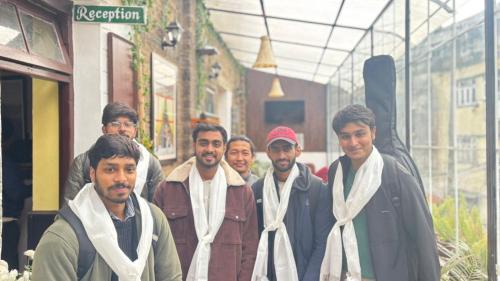 a group of men standing outside of a building at Mellow Fellow Hostel Darjeeling in Darjeeling