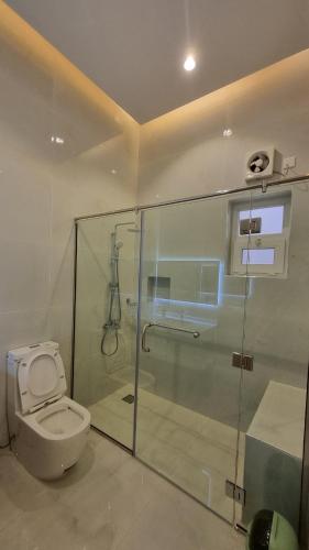a bathroom with a toilet and a glass shower stall at Elizabeth in Muscat