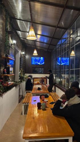 a group of people sitting at tables in a restaurant at Mellow Fellow Hostel Darjeeling in Darjeeling