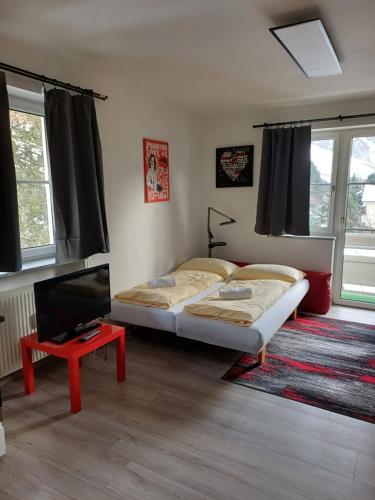 a bedroom with a bed and a tv and a table at Apartment Mountain View with Private Sauna in Bad Hofgastein