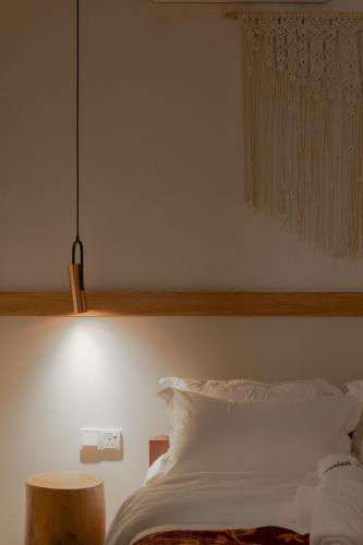 a bedroom with a white bed and a pendant light at Armenian House by IIP in George Town