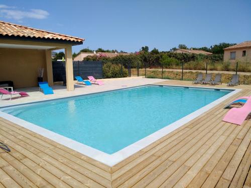 une piscine avec des chaises et une terrasse en bois dans l'établissement Mini villa, à Zonza
