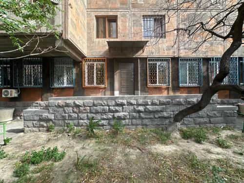 a building with a stone wall in front of it at Best Hostel in Yerevan