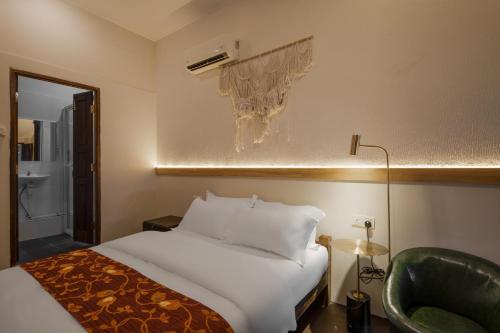 a hotel room with a bed and a chair at Armenian House by IIP in George Town