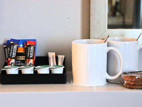 a table with two coffee cups and a tray of snacks at Garner Hotel Preston Samlesbury by IHG in Preston