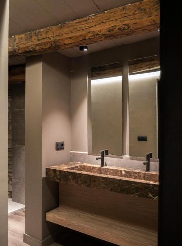 a bathroom with a large sink with two mirrors at Casa Rural Aracanciás in Borrastre