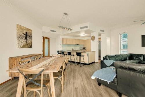a kitchen and a living room with a wooden table at Waves 203 on Currumbin in Gold Coast