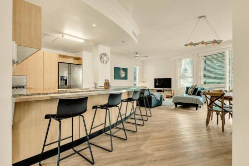 a kitchen and living room with a bar and chairs at Waves 203 on Currumbin in Gold Coast