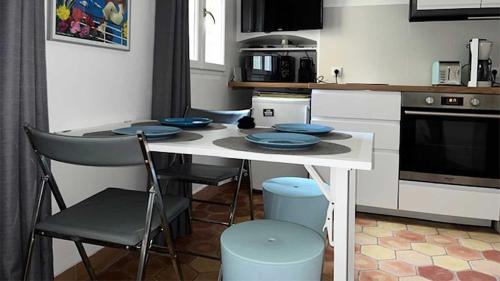 d'une cuisine avec une table et des plaques bleues. dans l'établissement Le rocher, à Antibes