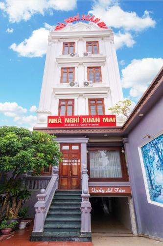Un edificio blanco con un cartel rojo encima. en Nhà Nghỉ Xuân Mai, en Lạng Sơn