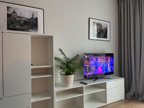 a living room with a tv on a white cabinet at Metro Art Scandic Studio in Warsaw