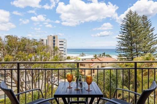 a table on a balcony with a view of the ocean at Ocean Breeze at Palm Beach in Gold Coast