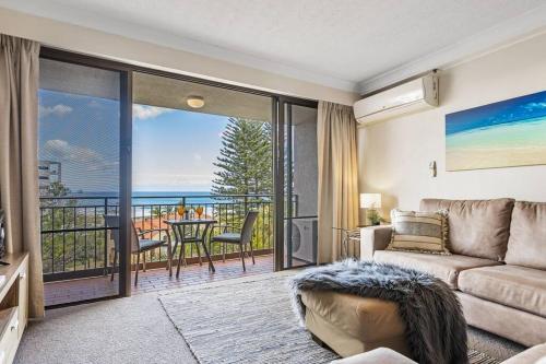 a living room with a couch and a view of the ocean at Ocean Breeze at Palm Beach in Gold Coast