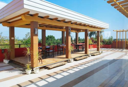 a pavilion with tables and chairs on a patio at RedDoorz @ Benelio Suites Pavia Iloilo in Pavia