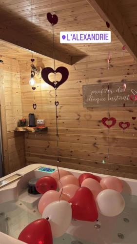 a room with a tub with red and white balloons at LAlexandrie in Régusse