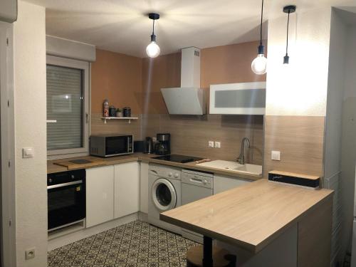 une cuisine avec un évier et une machine à laver dans l'établissement Appartement T3, à Bagnères-de-Bigorre