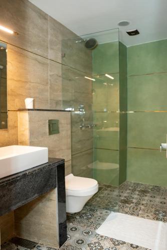 a bathroom with a toilet and a glass shower at G Ramayana in Kathmandu