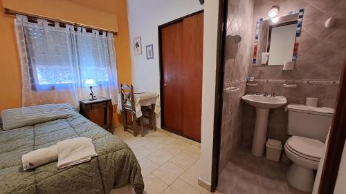 a bathroom with a bed and a sink and a toilet at Hotel Albert in Villa Gesell