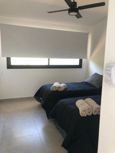 two beds in a room with towels on them at Olivos del Solar in Villa General Belgrano