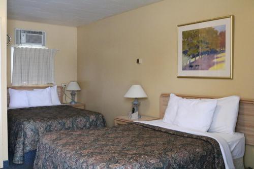 Wakaw Lodge Motel في Wakaw: غرفه فندقيه سريرين ومصباحين