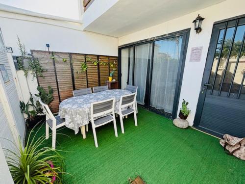 a table and chairs on a patio with green grass at Tikaz Ravine à St Pierre in Saint-Pierre