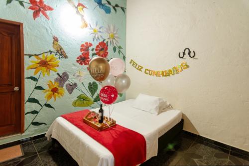 a room with a bed with balloons on a table at Hotel Orillas del Pizano in Jardin